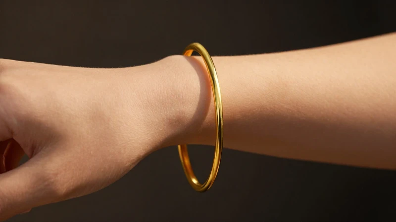 Pulsera dorada en la muñeca femenina
