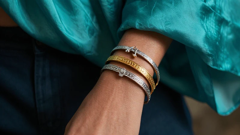Pulseras doradas y plateadas sobre un fondo lujoso
