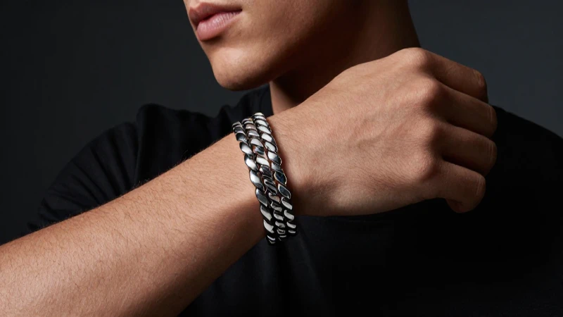 Modelo masculino luce pulseras plateadas elegantes