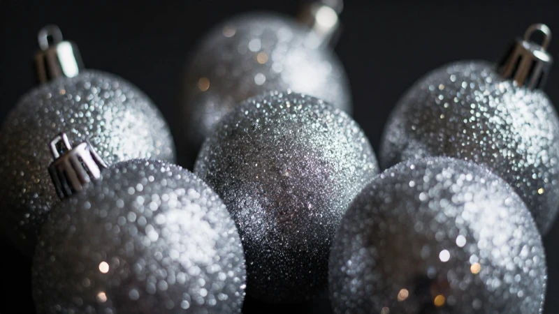 Adornos navideños plateados brillan en oscuridad