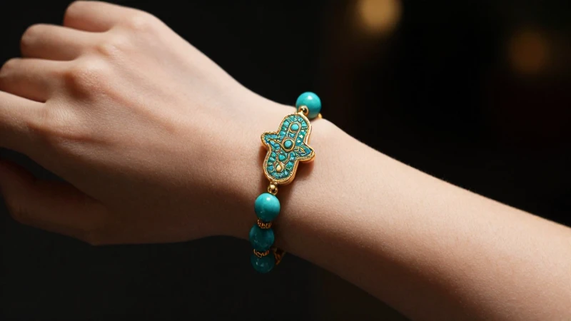 Pulsera Hamsa turquesa en mano elegante