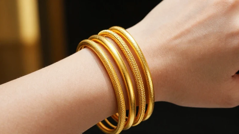 Pulseras doradas apiladas en mano, lujo vibrante