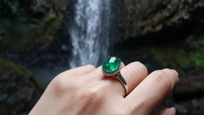Anillo esmeralda en mano, fondo vibrante