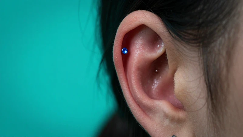 Piercing en la oreja, iluminación dramática y turquesa